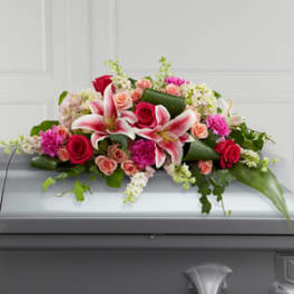Pink and white floral casket spray with roses and lilies