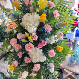 Tall mixed floral standing arrangement with pink, white, and yellow blooms