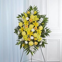 Standing floral spray with yellow and white flowers on an easel