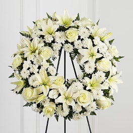 White floral wreath on a black stand