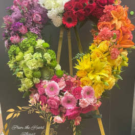 Heart-shaped floral wreath in rainbow colors on an easel