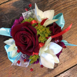 Small corsage with red roses and white flowers on blue ribbon
