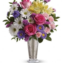 Bouquet of pink roses, daisies, and purple flowers in a silver vase