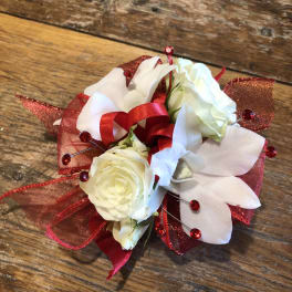 White roses with white orchids and red ribbon accents