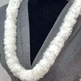 White fluffy lei-style garland displayed on a gray dress form