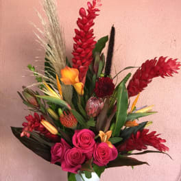 Tropical bouquet with pink roses and red ginger flowers in a white vase