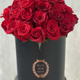 Red roses arranged in a black cylindrical box