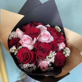 Bouquet of red and pink roses with small white filler flowers