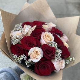 Bouquet of red and blush roses wrapped in brown paper