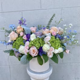 Pastel rose bouquet in a white hat box with blue accents