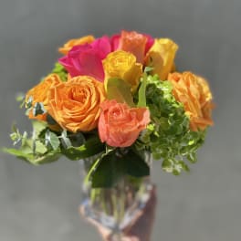 Bouquet of multicolored roses in a clear glass vase
