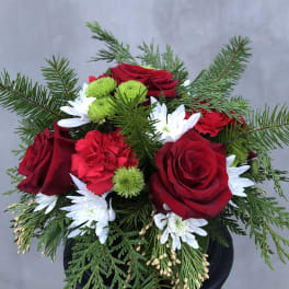 Red roses with white daisies and green pompons in a black vase