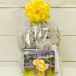Cellophane-wrapped gift set with gray plush toy and 'Jamie Giraffe' book topped with a yellow bow
