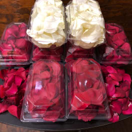 Plastic boxes filled with red and white rose petals