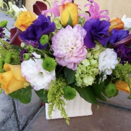 Colorful mixed bouquet with roses, dahlias, and calla lilies in a white vase