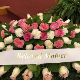 Pink and white floral spray with a "Beloved Mother" ribbon