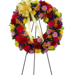 Colorful floral wreath on a black easel with a yellow bow