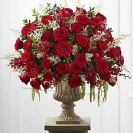 Large red rose arrangement in a decorative urn vase