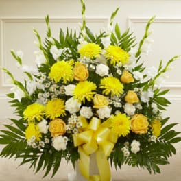 Yellow and white floral arrangement with a yellow ribbon in a vase
