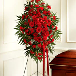 Red floral standing spray beside a casket