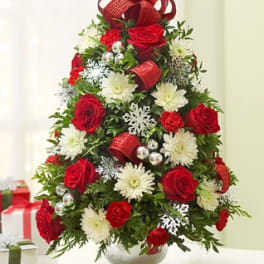Christmas tree-shaped bouquet of red roses and white flowers in a vase