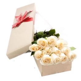 Cream roses in a beige gift box with a pink ribbon