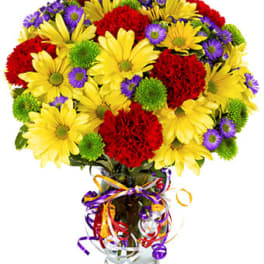 Bouquet of yellow daisies, red carnations, and purple asters in a glass vase
