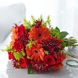 Bouquet of red and orange flowers with green accents