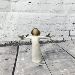 Small angel figurine in a white dress with outstretched arms