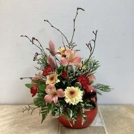 Mixed floral arrangement in a red ceramic vase with tall branches
