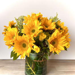 Bouquet of yellow sunflowers in a glass vase