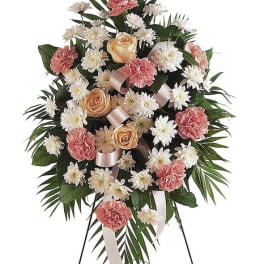 Standing floral spray with pink carnations, peach roses, and white daisies