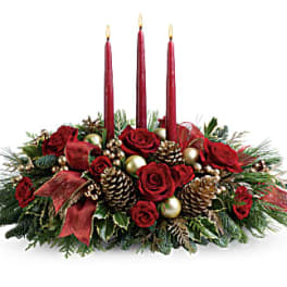 Holiday centerpiece with red roses, candles, pinecones, and gold ornaments