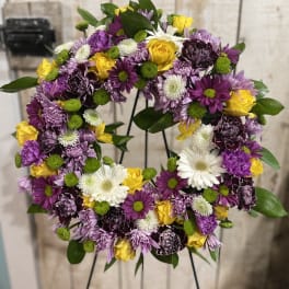 Circular floral wreath with purple, yellow, and white blooms