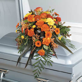 Orange and yellow floral spray on a silver casket