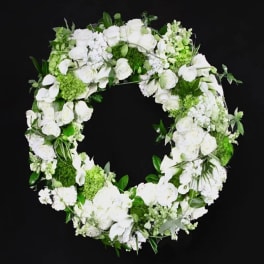 White floral wreath with roses and orchids on a black background
