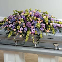 Lavender and peach floral spray on a silver casket