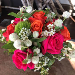 Bouquet of hot pink and orange roses with white filler flowers