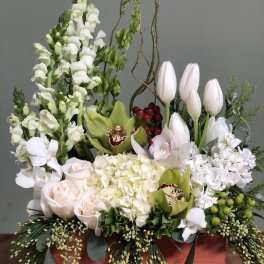 Mixed floral arrangement with white tulips, roses, orchids, and snapdragons in a wooden box