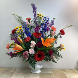 Colorful mixed flower arrangement in a white vase