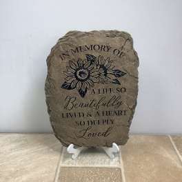 Memorial stone plaque with sunflower design and engraved text on a stand