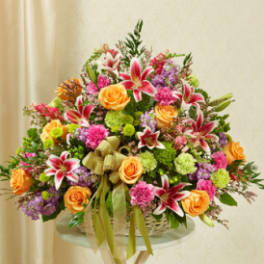Large mixed bouquet with orange roses and pink lilies in a basket