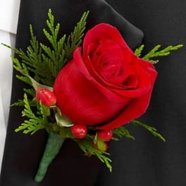 Red rose boutonniere with green foliage and berry accents