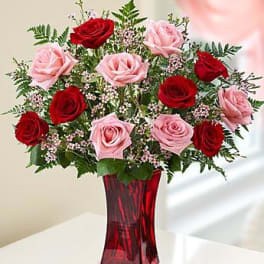 Red and pink roses in a red glass vase