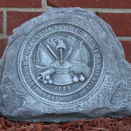 Engraved stone marker with a circular seal against a brick wall