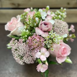 Pink roses and mixed blooms arranged in a compact bouquet