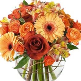 Bouquet of orange and yellow flowers in a clear glass vase
