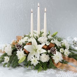 White floral centerpiece with three tall candles