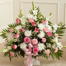Pink and white floral arrangement with a pink ribbon bow