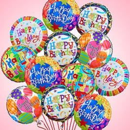 Cluster of colorful Happy Birthday balloons on a pink background